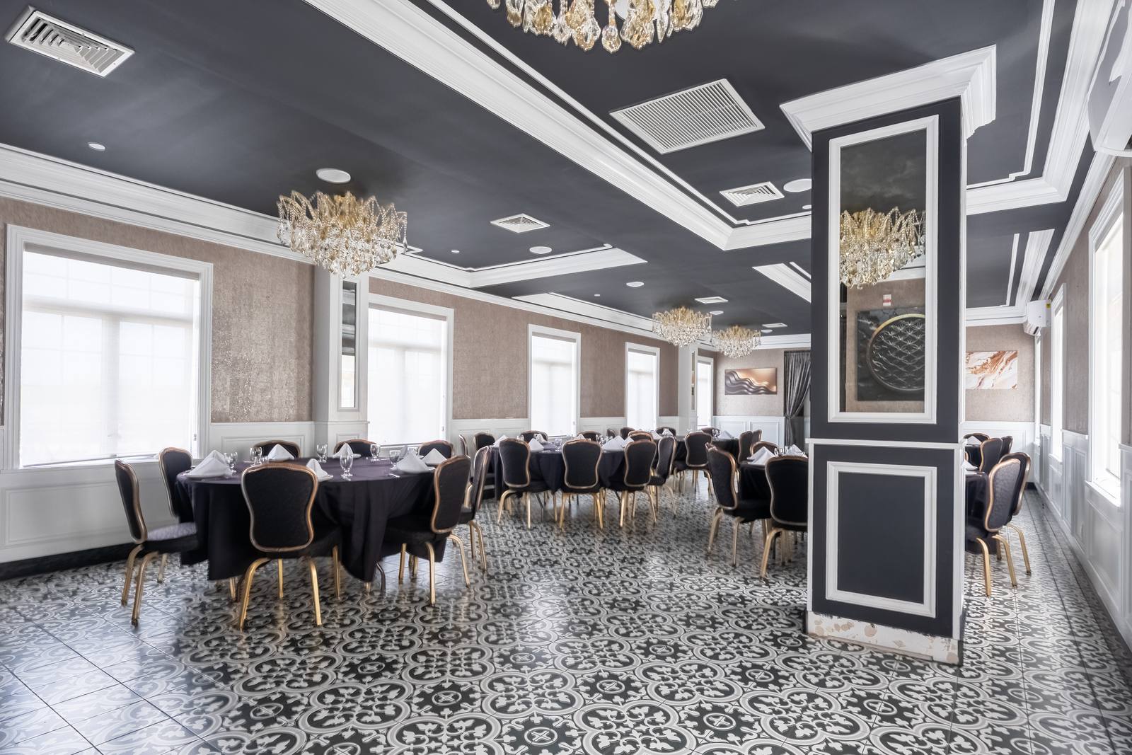 The Chandelier Room with wainscoted walls, mirrored column and tables set for dinner