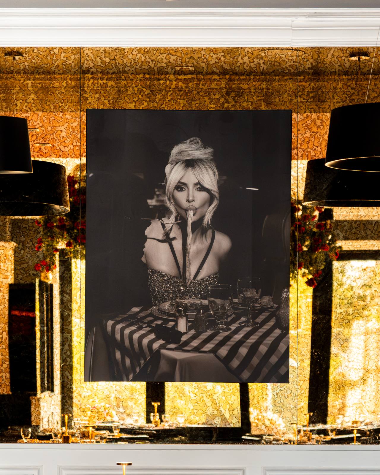 Wall portrait and gold mirrored walls in the Baci dining room