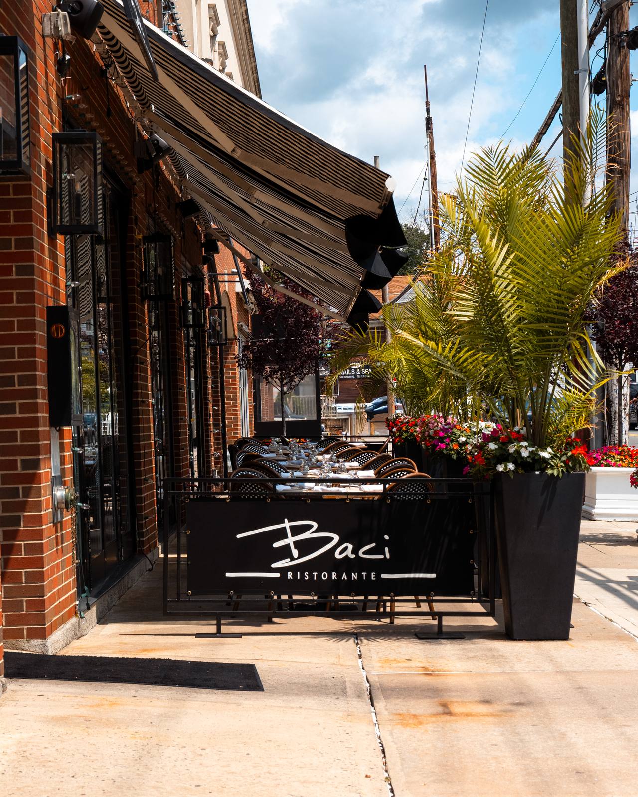 Sidewalk patio tables with bistro chairs outside Baci