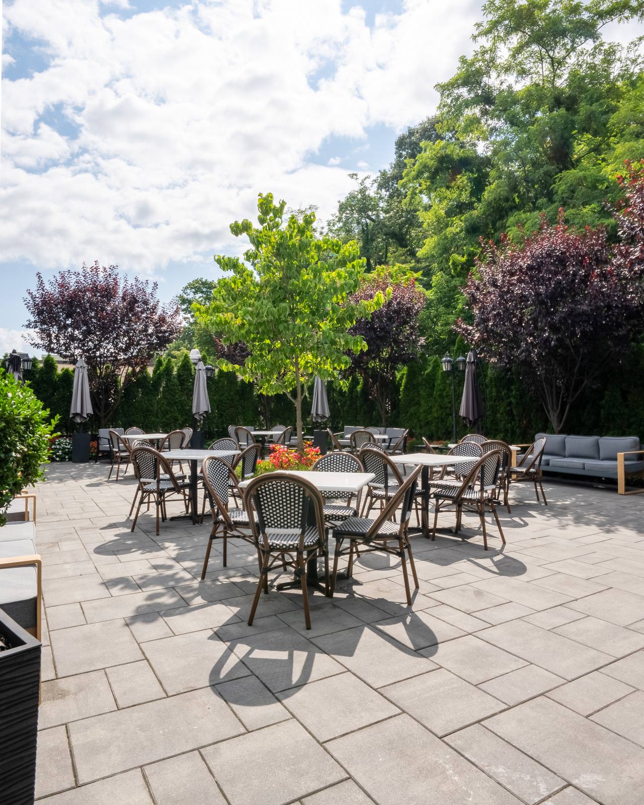 The private Rooftop patio with bistro chairs, umbrellas and lounge seating among the greenery