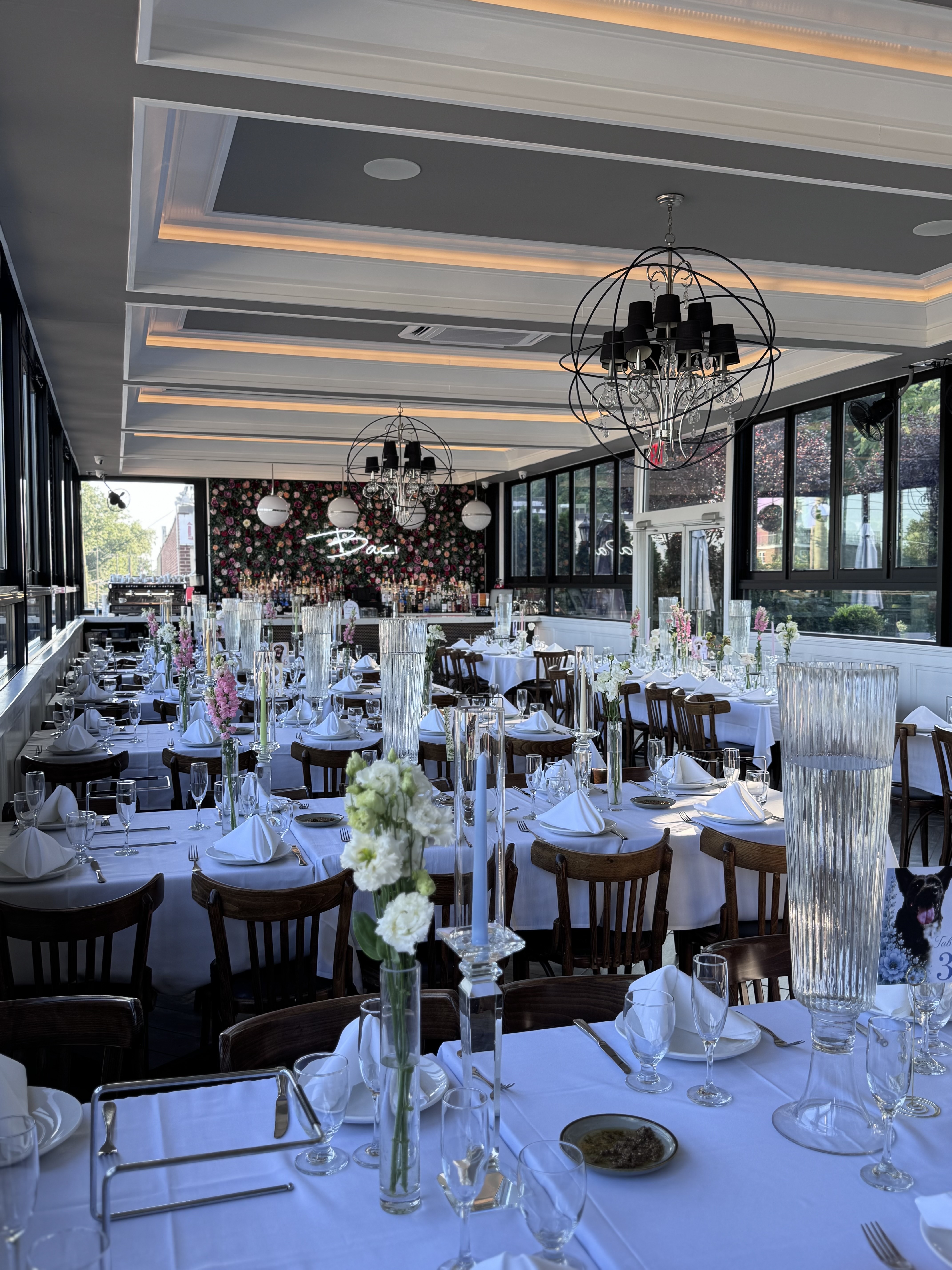 Long banquet table on The Rooftop set with white linens, bud vases and taper candles