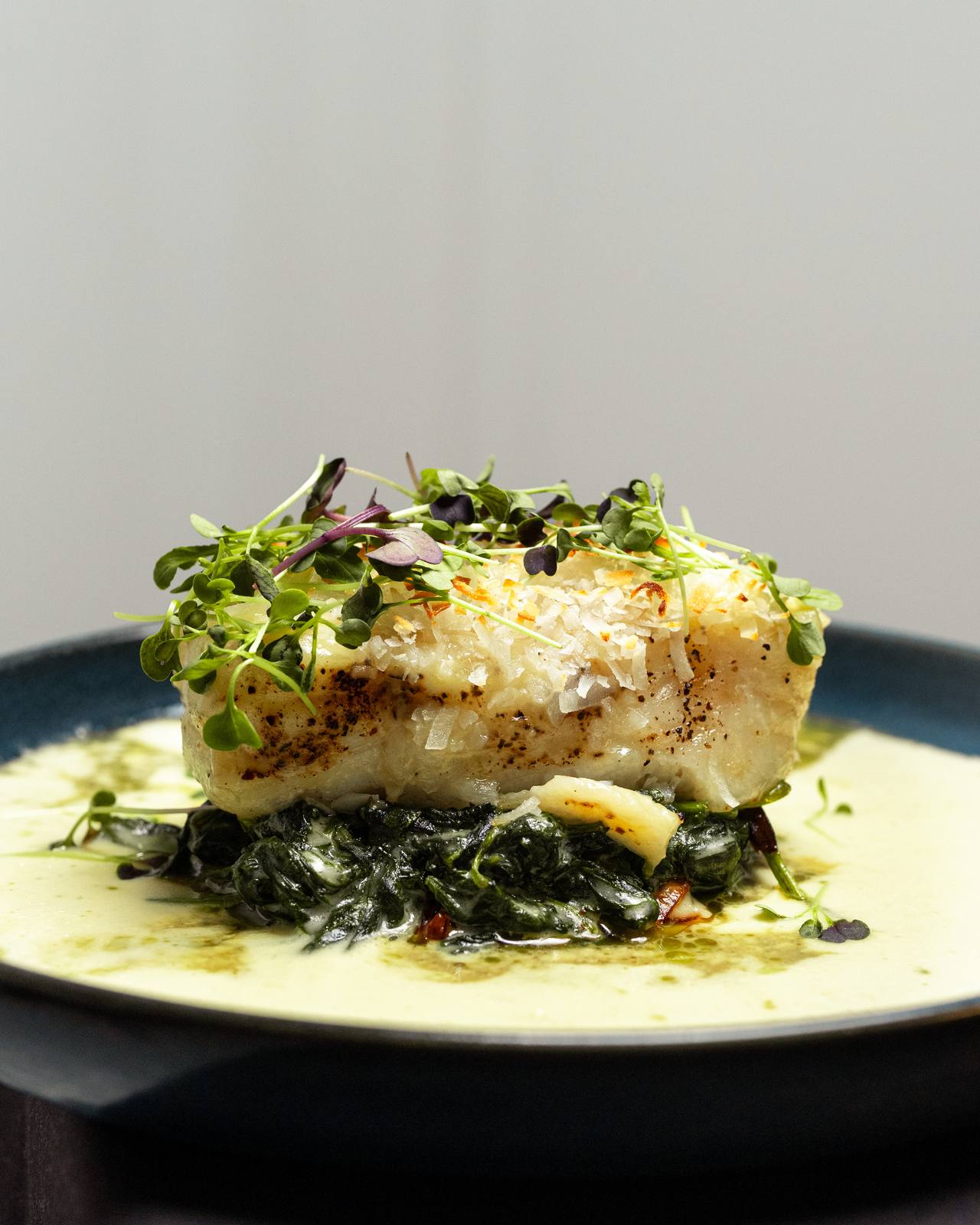 Coconut-crusted Chilean seabass over wilted spinach at Baci